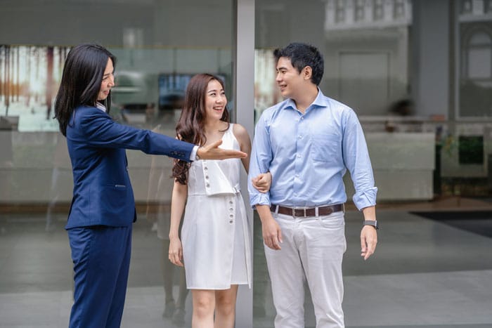 asian-saleswoman-welcoming-the-couple-customer-to-2024-10-18-17-29-58-utc